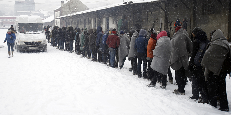 Migrants queue for food in front of an abandoned warehouse in Belgrade, Serbia, Wednesday, Jan. 11, 2017. Hundreds of migrants are sleeping rough in parks and make-shift shelters in the Serbian capital in freezing temperatures waiting for a chance to move forward toward the European Union. (AP Photo/Darko Vojinovic)