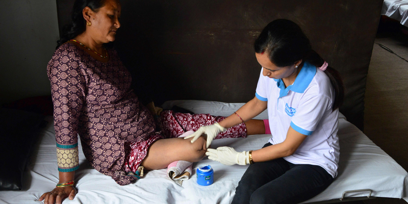 In this photograph taken on March 31, 2017, a Nepalese physiotherapist treats an earthquake survivor at a clinic in Kathmandu. With just seven health workers for every 10,000 people, Nepal was grossly ill-equipped when the massive 7.8-magnitude earthquake struck on April 25, 2015, levelling whole villages and killing 9,000.  / AFP PHOTO / Prakash MATHEMA / To go with 'Nepal-quake-anniversary-disability' FEATURE by Annabel SYMINGTON