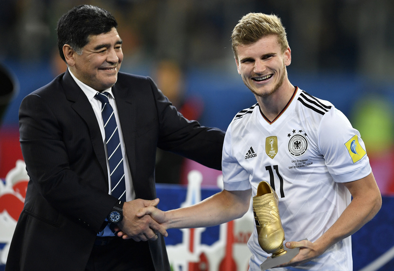 Germany's Timo Werner is congratulated by soccer legend Diego Maradona, left, after he was awarded the trophy as best scorer after Germany won 1-0 in the Confederations Cup final soccer match between Chile and Germany, at the St.Petersburg Stadium, Russia, Sunday July 2, 2017. (AP Photo/Martin Meissner)