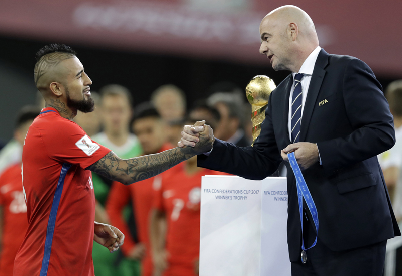 FIFA President Gianni Infantino, right, shakes hands with Chile's Arturo Vidal at the end of the Confederations Cup final soccer match between Chile and Germany, at the St.Petersburg Stadium, Russia, Sunday July 2, 2017. Germany won 1-0. (AP Photo/Thanassis Stavrakis)