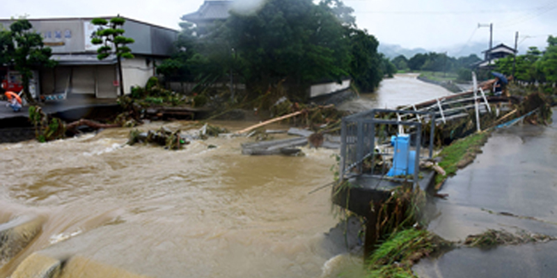 A local resident looks at a broken bridge due to heavy flooding in Asakura, Fukuoka prefecture, on July 6, 2017. At least 15 people are missing after huge floods swept away houses in southern Japan, tearing up roads as roiling waters surged through villages, authorities said, after unprecedented rainfall.JAPAN OUT / AFP PHOTO / JIJI PRESS AND AFP PHOTO / STR / Japan OUT