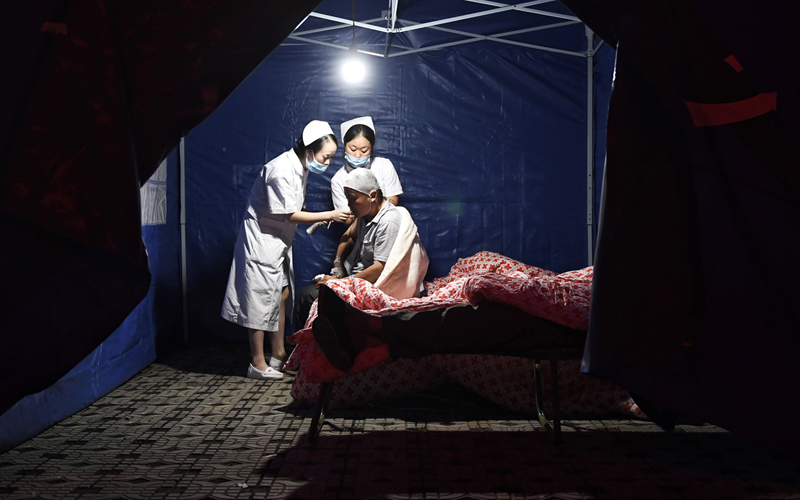 In this photo released by China's Xinhua News Agency, medical personnel treat an injured man at the People's Hospital in Jiuzhaigou county in southwestern China's Sichuan province, Wednesday, Aug. 9, 2017. A strong earthquake shook a mountainous region in southwestern China near a famous national park, killing people and knocking out power and phone networks. (Liu Kun/Xinhua via AP)