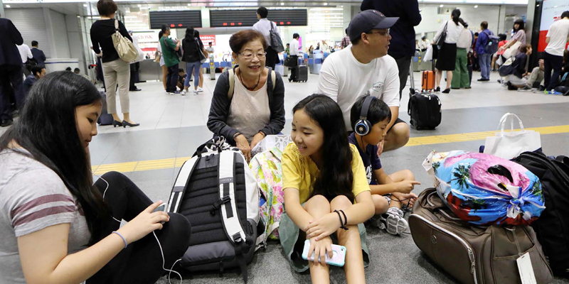 Passengers wait for the bullet train "Shinkansen" to resume operation in Osaka on June 18, 2018 following an earthquake. A strong quake hit western Japan early June 18, but there were no immediate reports of major damage or risk of tsunami waves, officials said. / AFP PHOTO / JIJI PRESS / STR / Japan OUT