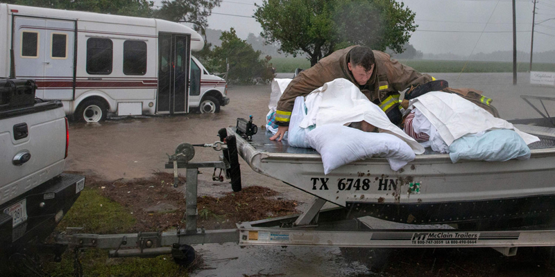 A Lumberton firefighter holds on to two nursing home patients as a member of the Cajun Navy drives his truck during the evacuation of a nursing home due to rising flood waters in Lumberton, North Carolina, on September 15, 2018 in the wake of Hurricane Florence. - Besides federal and state emergency crews, rescuers were being helped by volunteers from the "Cajun Navy" -- civilians equipped with light boats, canoes and air mattresses -- who also turned up in Houston during Hurricane Harvey to carry out water rescues. (Photo by Alex Edelman / AFP)